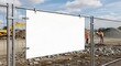 © textura - information board with white blank mockup on metal fence of construction site side view