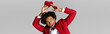 © Bliss - Young man in elegant red suit joyfully holds heart symbol in modern setting
