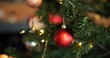 © Nina25/peopleimages.com - Background, Christmas and decoration with bauble on tree in home for celebration, event or tradition. Festive, holiday and wallpaper with ball in apartment for aesthetic, December or winter season
