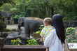 © leungchopan - Mom and infant enjoy view of elephant at zoo