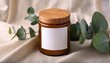 © Scott - ceramic candle jar mockup with wood lid and blank label on beige linen with eucalyptus branch