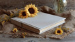 © Thiago - A photo album lies open on a rustic surface with a couple of sunflowers resting on top, alongside dried flowers. The scene evokes a sense of nostalgia and cherished memories.