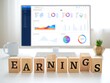 © Mamun Design - Earnings spelled out in wooden blocks on office desk