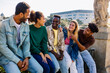 © Xavier Lorenzo - Diverse group of young friends bonding at city street. Multiracial college students hanging out after classes outdoors