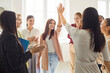 © Studio Romantic - Female cheerful colleagues giving high five on meeting celebrating success, making deal or business achievement. Women company employees applauding in office congratulating woman partner.