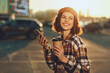 © SHOTPRIME STUDIO - woman coffee phone smile urban golden, young woman holding takeaway coffee and phone, smiling in city light and backlight with authenticity, candid lifestyle, golden hour glow, mindful living.