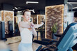 © Novak - A girl is stretching and warming up on the treadmill in the gym.