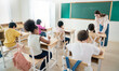© paulaphoto - Portrait of little caucasian pupil writing at desk in classroom at elementary school. Student girl study doing test in primary school. Children writing notes in classroom. Education knowledge banner