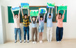 © paulaphoto - Diverse group of smile children proudly holding up eco-themed drawings in classroom, promote environmental awareness and creativity. World earth day concept