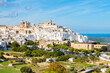 © pkazmierczak - Panoramic view of the whitewashed hilltop town of Ostuni, known as the “White City,” with its cathedral and sea views in the background, Apulia, Italy