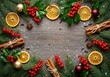 © CK Studio - Elegant Christmas frame with pine, holly, dried oranges, and cinnamon sticks on a snowy wooden background, copy space.