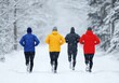 © oksa_studio - Group of four vibrant runners is exercising, enjoying a winter run along a snowy forest path during falling snowflakes