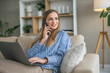© Miljan Živković - Woman smiling talking on smart phone working from home