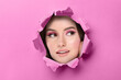 © New Africa - Woman with beautiful makeup, closeup. View through torn hole in pink paper