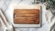 © app - wooden cutting board on pale stone slab and marble countertop, draped linen cloths and eucalyptus sprig, serene minimalist kitchen scene