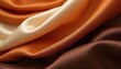 © Maryna - Luxurious fabric in shades of orange and brown. Smooth satin texture with elegant folds. Different tones of warm colored silk fabric. Brown, beige and cream colored textile background.