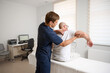 © Василь Івасюк - Chiropractor adjusting male patient’s shoulder in clinic. Physiotherapist performing manual therapy to relieve pain, improve mobility, support rehabilitation after injury or musculoskeletal disorder.