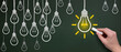 © MOHAMED - Succeed in finding solution after try and failure. Businessman drawing lightbulbs on chalkboard