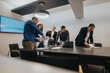 © qunica.com - A group of business professionals reviewing documents and working together in a bright, modern conference room. Collaboration, productivity, and teamwork in a professional workspace.