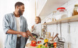 © Prostock-studio - Cute little african american girl and her dad cooking in kitchen at home