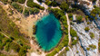 © AmazingAerialAgency - Aerial view of a turquoise pool surrounded by rocky terrain and verdant trees, a hidden oasis glistening under the sun, inviting exploration and wonder, Knin, Sibenik-Knin County, Croatia.