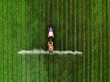© oticki - Tractor spraying pesticide on green agricultural crop field