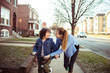 © Davor - Adult mother and child son smiling while biking on suburban sidewalk