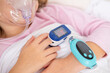 © kittyfly - Young person, girl receiving oxygen therapy, Child lies with oxygen mask and pulse oximeter on finger, patient health tracker, pediatric respiratory care, recovery hospitalization, health monitoring
