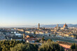 © Mint Images - View across the rooftops of Florence, historic renaissance architectural landmarks, the Duomo and campanile to the mountains beyond.