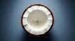 © sahenur89 - A close up shot of a halved coconut showing the white flesh and brown shell on a blue background