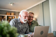 © Migma_Agency - Senior couple enjoying online content on laptop at home