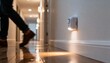 © soysuwan123 - A person walks down a well-lit hallway, with a motion sensor light illuminating the floor.