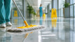 © Ula - Staff member cleaning hospital corridor with a mop