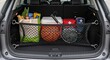 © HussainKhan - Car trunk storage organizer with groceries and supplies showcasing a tidy vehicle cargo area with a black mesh divider