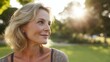 © Adriana - Backlit image of an Attractive sexy mature blond woman posing in a park looking way