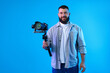 © New Africa - Videographer using gimbal stabilizer with camera on light blue background