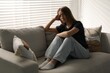 © New Africa - Depressed teenage girl on sofa at home