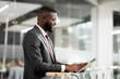 © Prostock-studio - African american man in suit CEO using business mobile app on digital tablet, black businessman trading on stocks and markets while having break at office, panorama with copy space, side view
