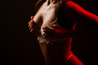 © Darius - Woman poses in lingerie beneath red neon light in a dimly lit setting