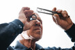 © Parilov - Elderly jewelry male examining raw diamond with magnifier and tweezers