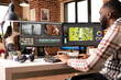 © DC Studio - Black male vfx artist works remotely at desk, mixing and adding visual effects to video clips. Creative african american editor using dual monitors for efficient post production workflow.