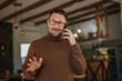 © Miljan Živković - Man talking on mobile phone looking surprised and gesturing