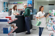 © DC Studio - Senior man at the counter speaking with pharmacist about prescription medicine, asking for advice on heart health, blood pressure pills and pharmaceutical care during his pharmacy visit.