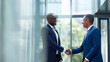 © Aillusionist - Two businessmen shake hands in an office lobby. Suitable for business, partnership, teamwork, success, negotiation, corporate, handshake, agreement concepts.