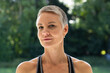 © Wavebreak Media - Mature woman sporting pixie haircut and pearl earrings wearing athletic tank posing in garden