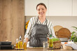 © Pixel-Shot - Young woman with sunflower oil cooking at table in kitchen