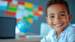 © venusvi - A cheerful young boy smiles brightly in a classroom setting, showcasing joy and curiosity about learning and exploration.