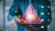 © PRIM - Business professional holding a tablet with warning symbol and digital folder icons, representing data breach risk, cybersecurity threats, information protection, secure storage