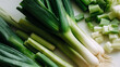 © pijav4uk - Freshly sliced leeks arranged neatly on a white surface for cooking preparation