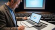 © photoplotnikov - Caucasian male adult setting up laptop in lecture hall for presentation